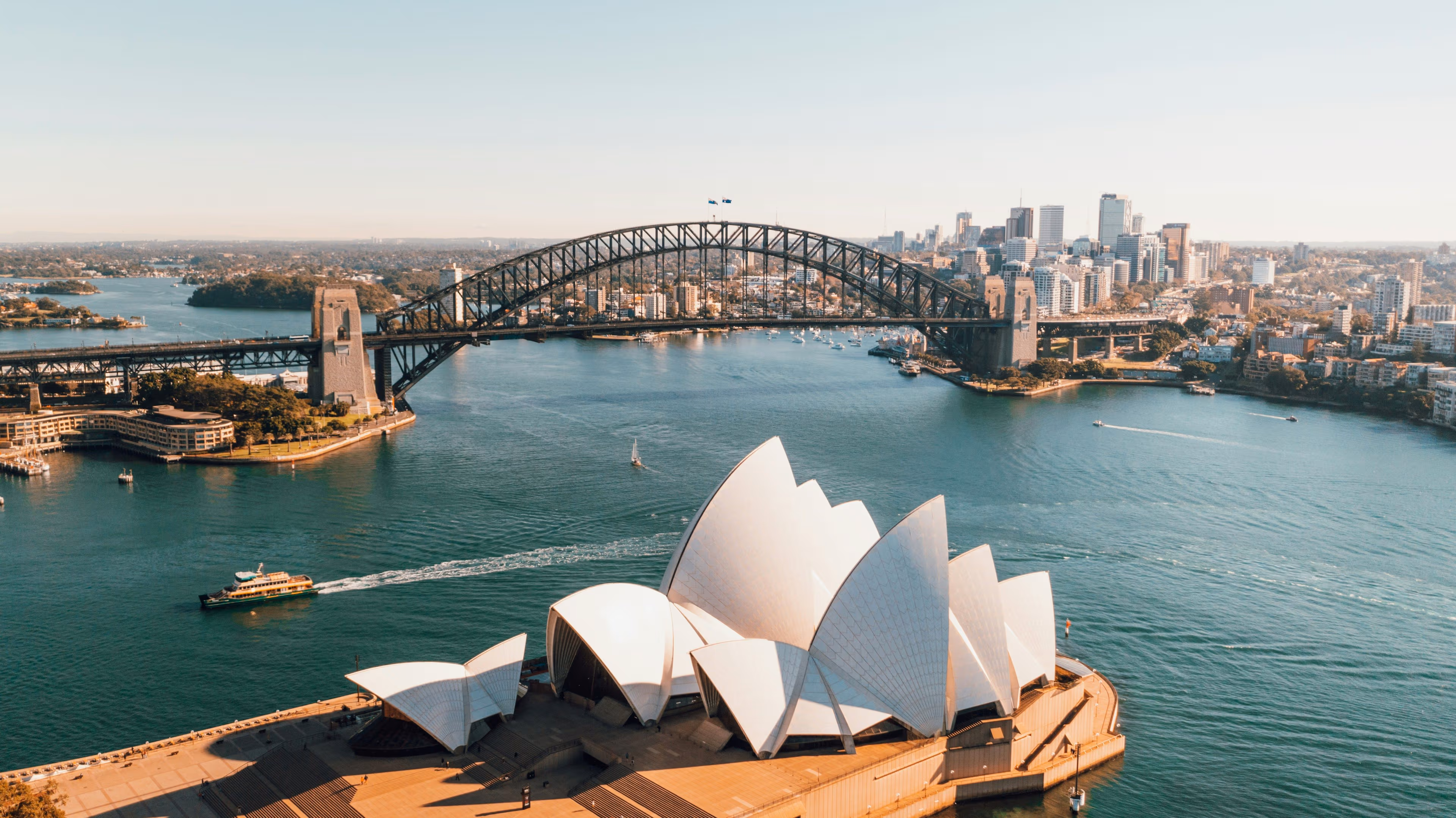 View of Sydney Harbour with the Harbour Bridge and Opera House. (Caleb/ Unsplash)