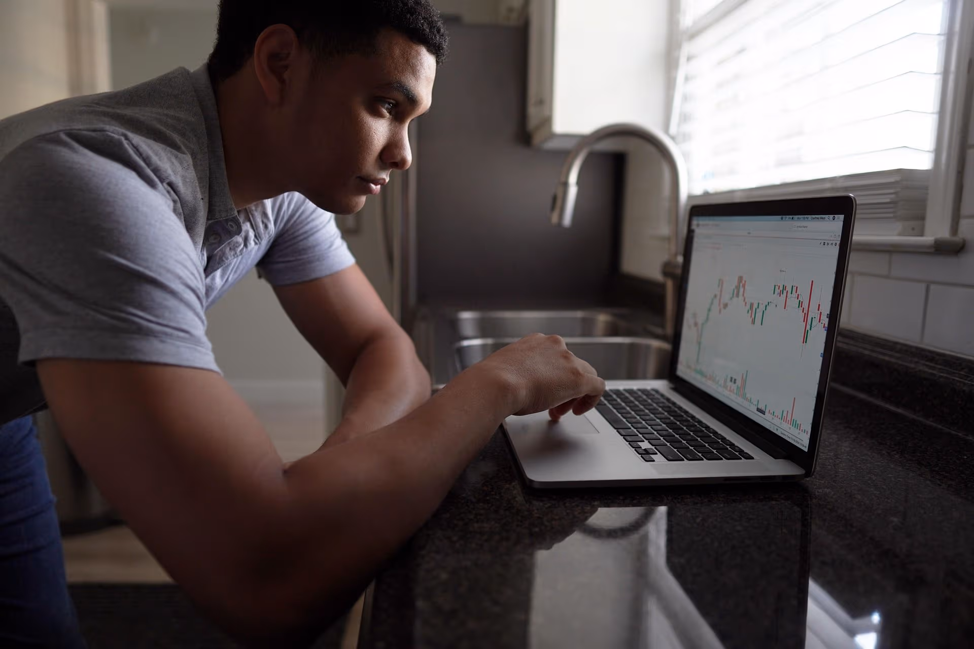 A man looks at a chart on his laptop. (TheInvestorPost/Pixabay)